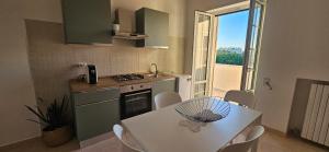 une cuisine avec une table blanche et une cuisine avec une fenêtre dans l'établissement La Loggia sul mare, à Tarente