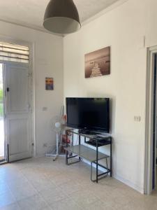 Una sala de estar con un televisor de pantalla plana en una pared. en Granelli - a pochi passi dal mare, en Granelli