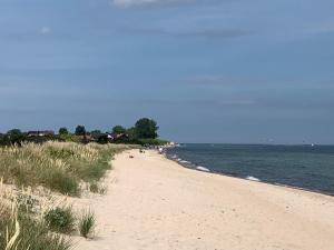 ein Sandstrand neben dem Meer mit Menschen darauf in der Unterkunft MECHELinn in Mechelinki