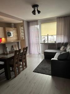 a living room with a couch and a table at 3 pokoje przy parku w Helu in Hel