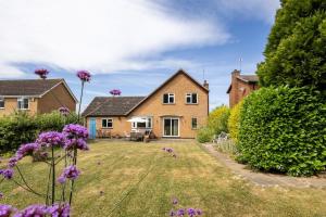 a house with purple flowers in the yard at Pilkington House in Hathern