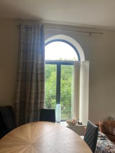 una sala da pranzo con un tavolo e una grande finestra di The Mill Sixmilewater Mill Antrim ad Antrim Altre 9 foto
