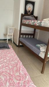 a room with two bunk beds and a chair at Oga Guasu casa con piscina exclusiva in Puerto Iguazú +5 photos