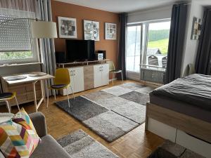 a bedroom with a bed and a table and a desk at Haus - Sonneck in Schonwald im Schwarzwald