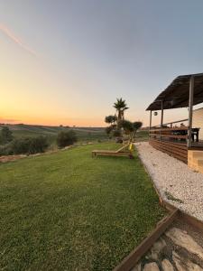 a grassy field with a pavilion and a palm tree at Casa vacanze Trinacria in Menfi