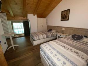 a bedroom with two beds in a room with wooden ceilings at Rifugio Lo Scoiattolo in Peio +9 photos