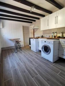 a kitchen with a washing machine and a table at Chez Pierre Et Deme in Saint-Jacques-des-Guérêts