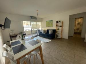 a living room with a table and a blue couch at Impecable departamento en Caballito. in Buenos Aires