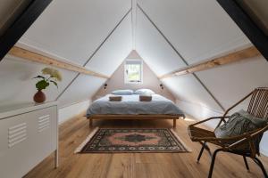 a bedroom with a bed in a attic at Vakantiehuisje Grijpskerke, hartje Walcheren in Grijpskerke +17 photos