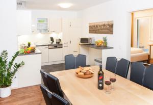 una cucina e una sala da pranzo con tavolo e bicchieri da vino di Landhaus Anni a Saalbach Hinterglemm