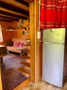 a kitchen with a refrigerator in a room at Vacation cottage house Enya in Koprivnik v Bohinju