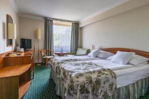 ein Hotelzimmer mit zwei Betten und einem Schreibtisch in der Unterkunft Hotel Bartan Gdansk Seaside in Danzig + 37 Fotos