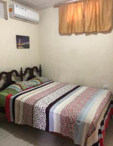 una camera da letto con un letto con una coperta sopra di Hospedaje Maluli 07 a Santa Elena