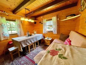 a living room with a table and a couch at Vacation cottage house Enya in Koprivnik v Bohinju