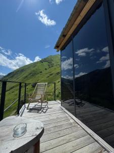 a wooden deck with a table and a chair on it at Pirdapira in Jut'a