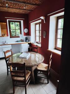a kitchen with a table and chairs in a room at La randonnée in Beaumont