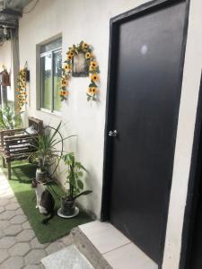 una porta nera con un gatto seduto di fronte di Hospedaje Maluli 07 a Santa Elena