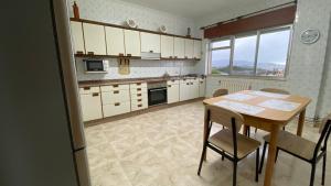 a kitchen with a wooden table and a table and chairs at Piso Mirador de San Cosme in San Cosme de Barreiros
