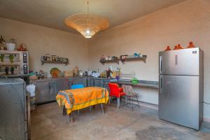 a kitchen with a table and a refrigerator at Riad Azelia in Moulay Ahmed