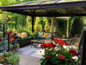 a pergola with red flowers on a patio at Via Veneto - Old Town in Niagara on the Lake