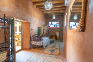 a room with a bed and a table and chairs at Riad Azelia in Moulay Ahmed