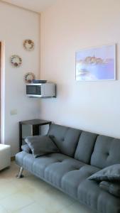 a blue couch in a living room with a microwave at Casa di Marco Independent apartment with spectacular view in Cala Gonone +12 photos
