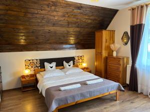 什恰夫尼察Pokoje Gościnne WIKTORIA的卧室里有一张大床，配有木质天花板