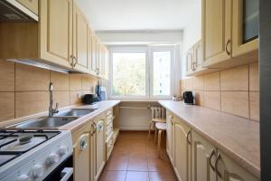 a kitchen with wooden cabinets and a sink and a window at Korczak Centrum Olsztyn in Olsztyn +10 photos