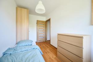 a bedroom with a bed and a dresser at Korczak Centrum Olsztyn in Olsztyn