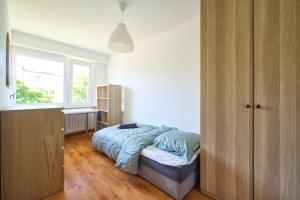 a bedroom with a bed and a window at Korczak Centrum Olsztyn in Olsztyn