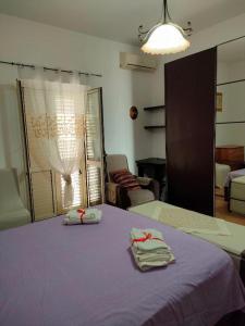 a bedroom with a purple bed with towels on it at International Apartment in Catanzaro Lido