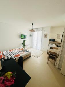 sala de estar con cama y escritorio. en Lumineux & cosy studio, en Poitiers