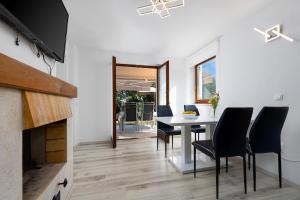 a dining room with a table and chairs and a fireplace at Apartment Mija with garden in Kornić