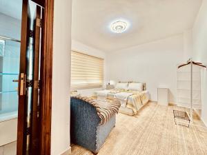 a bedroom with a bed and a couch and a window at Modern Apartment in Prime Location - Jabal Amman in Amman