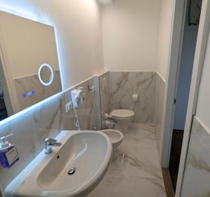 a white bathroom with a sink and a toilet at GuestHouse dei Fiori - Hituscany in Pisa +17 photos