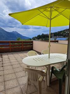 a table and chairs with a yellow umbrella on a roof at Logement 48m2- 2 chambres in Orcières