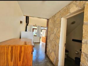 a kitchen with a stone wall and a refrigerator at Puerto Encuentro in Mar Azul