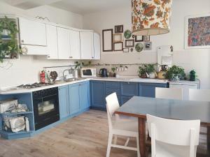 a kitchen with blue cabinets and a table with chairs at RaMaya casa d'artista 2 in Biella
