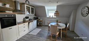a kitchen with a table and a clock on the wall at Haus Pusteblume in Eppenbrunn