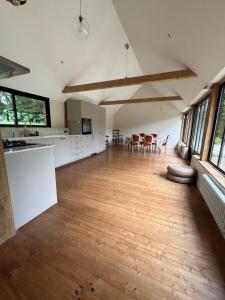a large kitchen with white cabinets and a hard wood floor at Dreamy Perche landscape in Bivilliers
