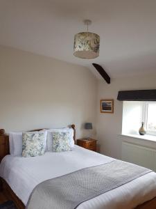 una camera da letto con un letto bianco e una finestra di Stanegate Cottage a Greenhead