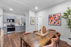 una cucina e una sala da pranzo con tavolo e sedie in legno di CityLine Group Stay | Near NYC | Private Parking a North Bergen