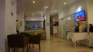 a living room with chairs and a tv on the wall at Hotel Marine in Ayvalık