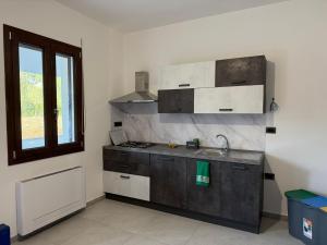 eine Küche mit Arbeitsplatte, Spüle und Fenster in der Unterkunft Villa Omodeo in Soddi