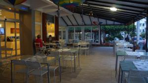a restaurant with tables and chairs and people in the background at Hotel Marine in Ayvalık