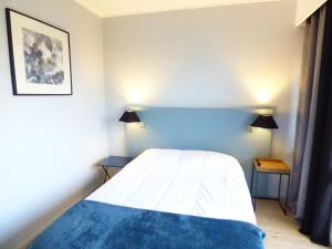 a bedroom with a bed with a blue headboard at Type 2 Catho Esa in Angers
