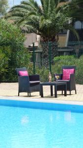 two chairs and a table next to a pool at VIEW port venus naturiste in Cap d'Agde +9 photos