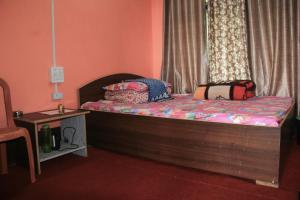 a small bedroom with a bed with a window at Jamuna Homestay in Kalimpong