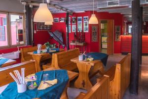 restauracja z drewnianymi stołami i krzesłami oraz czerwonymi ścianami w obiekcie Ristorante Albergo Al Donatore w mieście Teòr