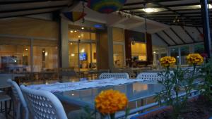 a dining room with a table and chairs and flowers at Hotel Marine in Ayvalık